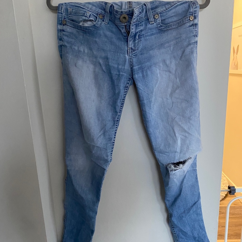 Blue jeans, distressed with rip on the knee